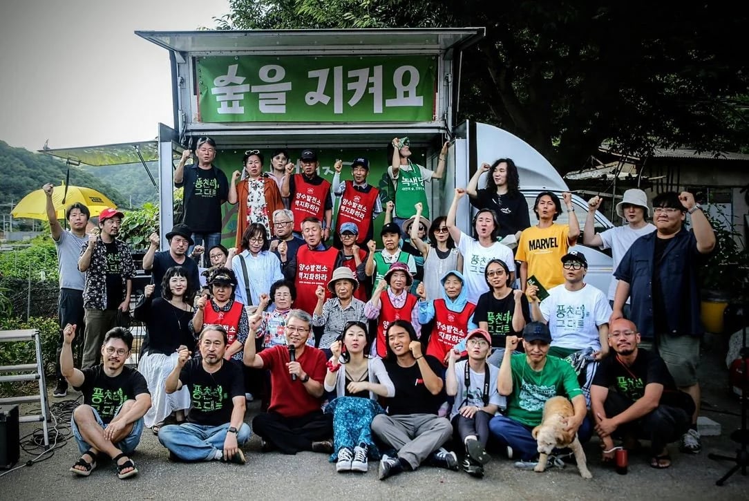 풍천리 마을 잔치를 마치고 무대 앞에 모여 주먹을 쥔 주민과 음악가들의 단체사진